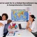 Happy professionals discussing a global recruitment plan with a consultant, highlighting the qualities to look for in a global recruitment agency. Comprehensive checklist for finding the right agency.